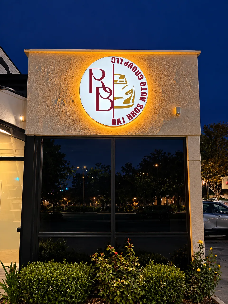 Raj Bros Auto Group circular illuminated wall logo