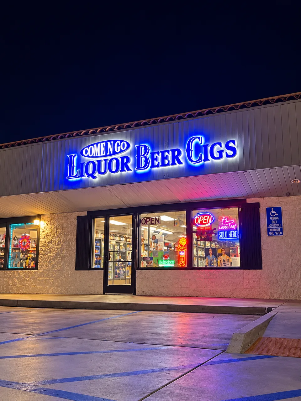 Liquor Beer Cigs blue illuminated storefront letters at night