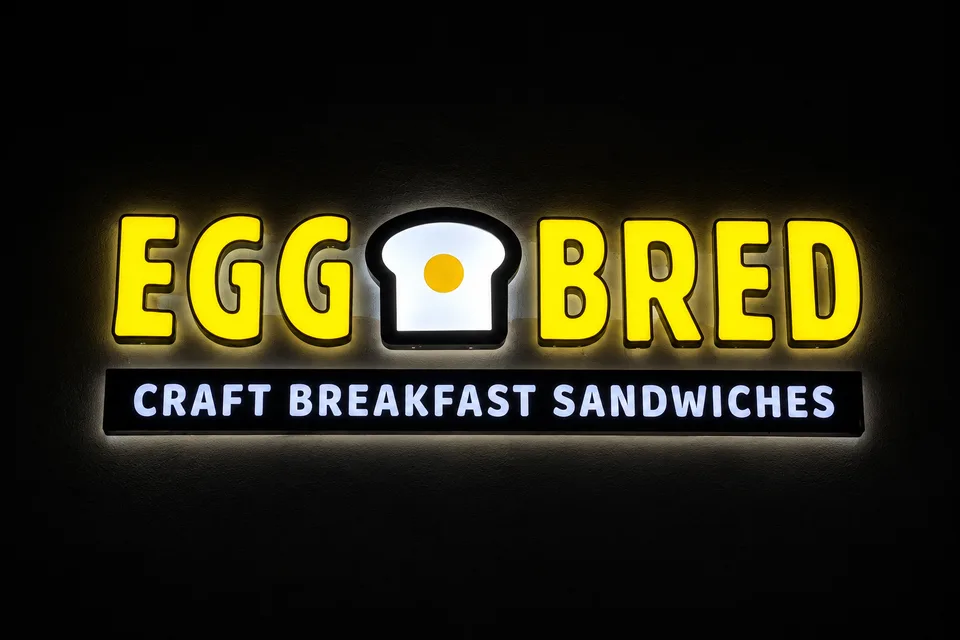 Close-up of Egg Bred illuminated letters and breakfast sandwich tagline