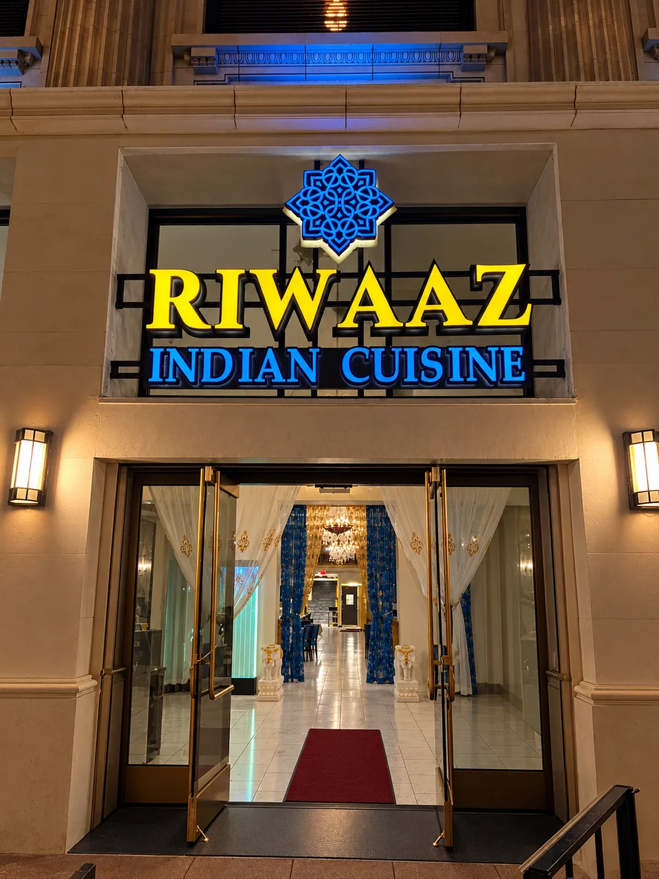 Riwaaz Indian Cuisine yellow and blue illuminated entrance sign